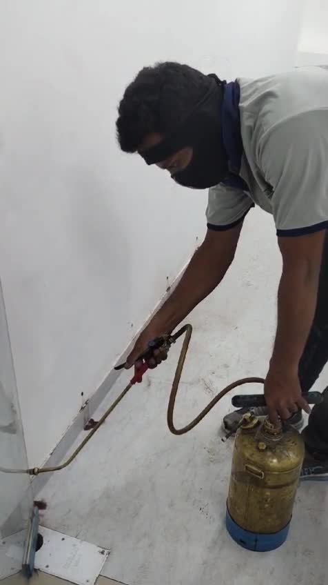 Technician applying pest control spray treatment